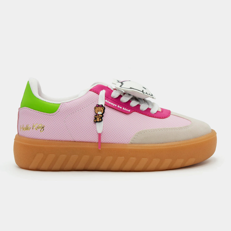 Tenis rosa pastel de Hello Kitty con plataforma café de liga, detalles en verde neón y dijes decorativos.