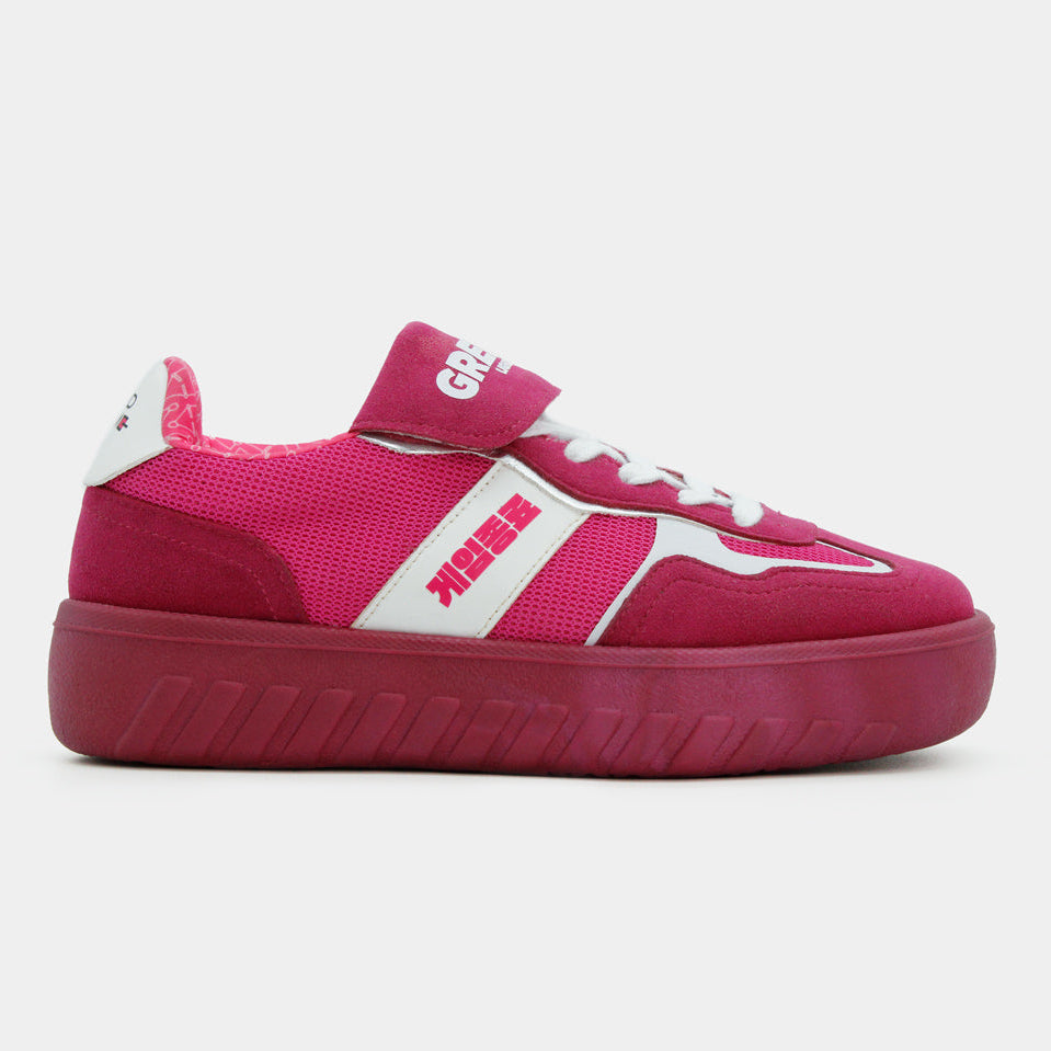 Tenis color magenta de Squid Game con suela de plataforma y franjas blancas laterales sobre fondo gris.